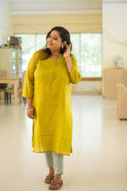 Haimanti mustard yellow kurta — side profile view showing straight midi silhouette